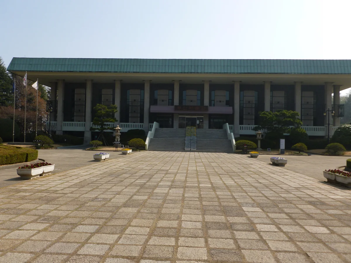 Fachada do Museu de Busan em Daeyeon, com colunas e escadaria diante de um pátio.